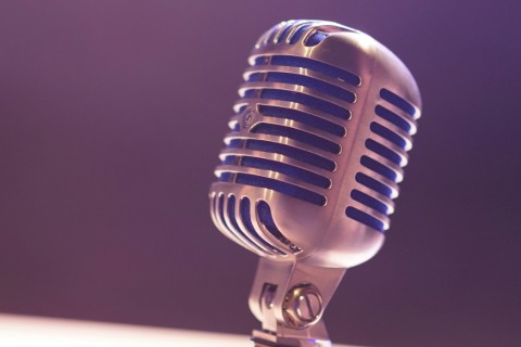 A silver microphone in a room with purple lighting.